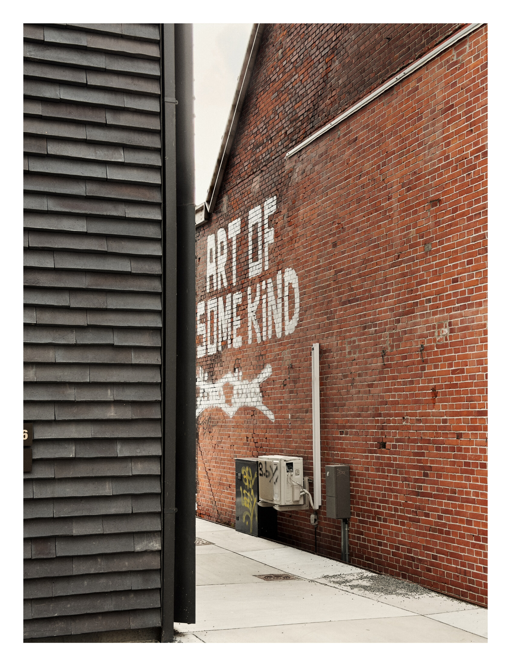 Brick warehouse wall painted with the words Art is everywhere and a white arrow