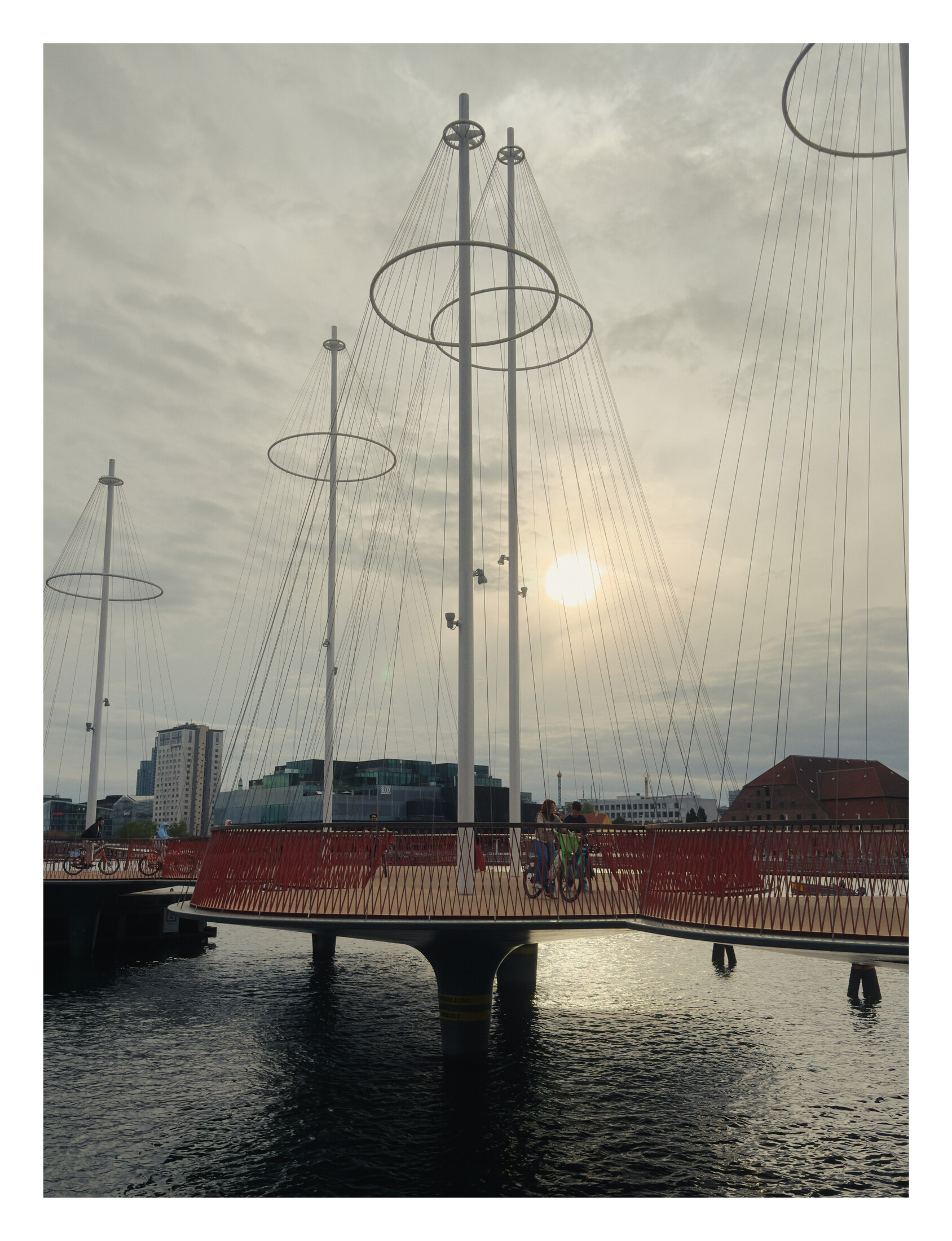 Sunlight behind the masts and red railings of Cirkelbroen